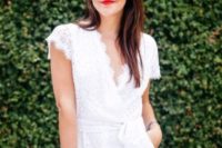 a white lace romper with a V-neckline, a red lip and a metallic clutch for a sexy modern bride-to-be