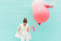 a white plain jumpsuit with a deep neckline and a cape, nude shoes and a top knot for a modern bride-to-be