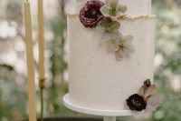 a white textural wedding cake with a gold glitter edge, fresh blooms is an elegant and romantic piece