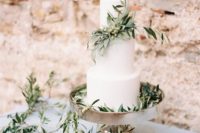 a white wedding cake with olive branches and olives is an ideal thing for a natural wedding or a rustic one