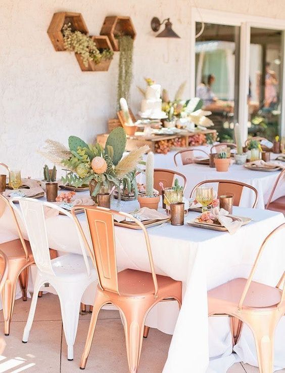 an outdoor summer bridal shower setting with copper chairs, cactus and pampas grass centerpieces and terracotta pots