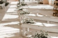 whitewashed benches decorated with olive branch bouquets is a great idea for a Tuscany wedding