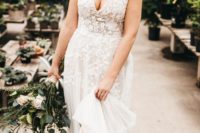 a beautiful floral lace A-line wedding dress with spaghetti straps, a depe V-neckline and a train