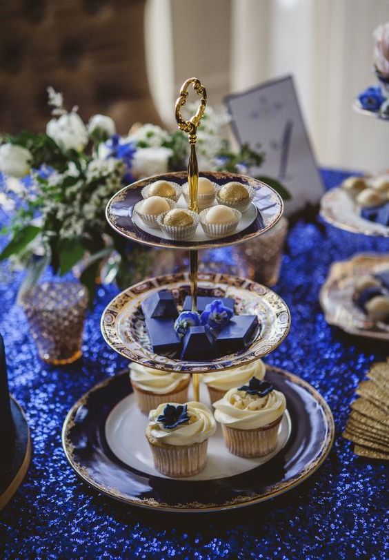 a beautiful vintage tiered wedding dessert stand of blue, white and gold pleates and saucepans is amazing