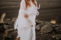 a boho Icelandic bride wearing a neutral polka dot wedding dress with bell sleeves and a crochet cover up