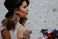 a boho lace halter neckline wedding dress with no sleeves to show off the bride’s tattoos on the shoulder and arm