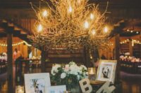 a branch chandelier, blooms, candles, framed photos and monograms