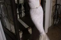 a breathtaking embellished strapless mermaid wedding dress with a layered tail and a mask