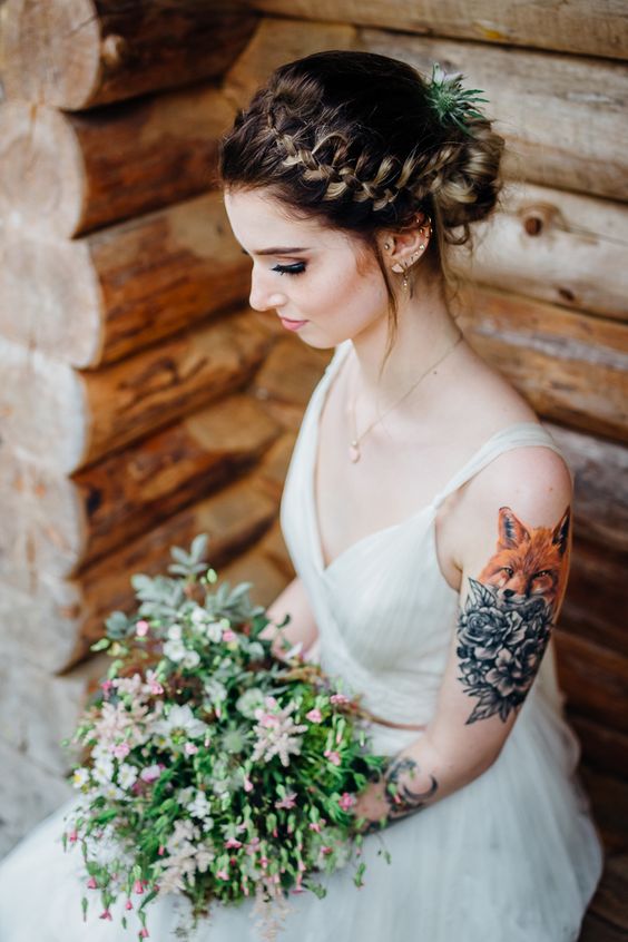 a chic A-line wedding dress on straps that shows off the bride's tattoos on the shoulder and arm in a beautiful way