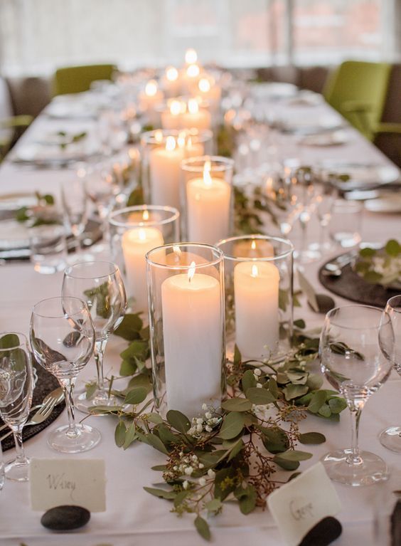 a chic and stylish Icelandic wedding tablescape with neutral linens, black placemats, greenery and white blooms and pillar candles