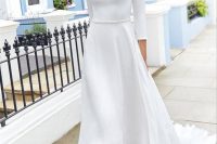 a chic minimalist wedding dress of plain fabric, with a bateau neckline, long sleeves and a high low skirt plus minimalist white shoes