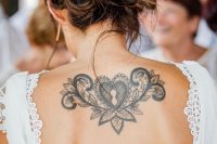 a chic plain and lace wedding dress with a cutout back that shows off a black ink tattoo at its best