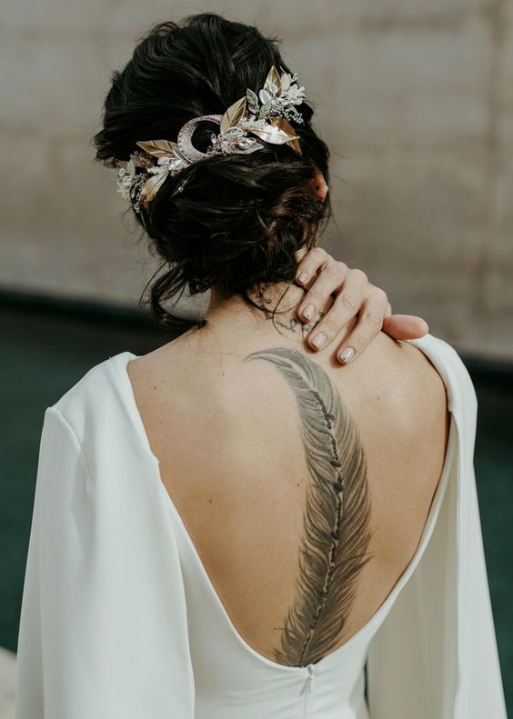 a chic plain wedding dress with a cutout back that shows off the stunning bride's tattoo there