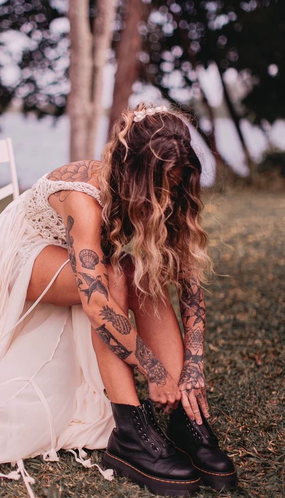 a chic wedding dress with a crochet bodice with straps and no sleeves to show off the bride's tattoos