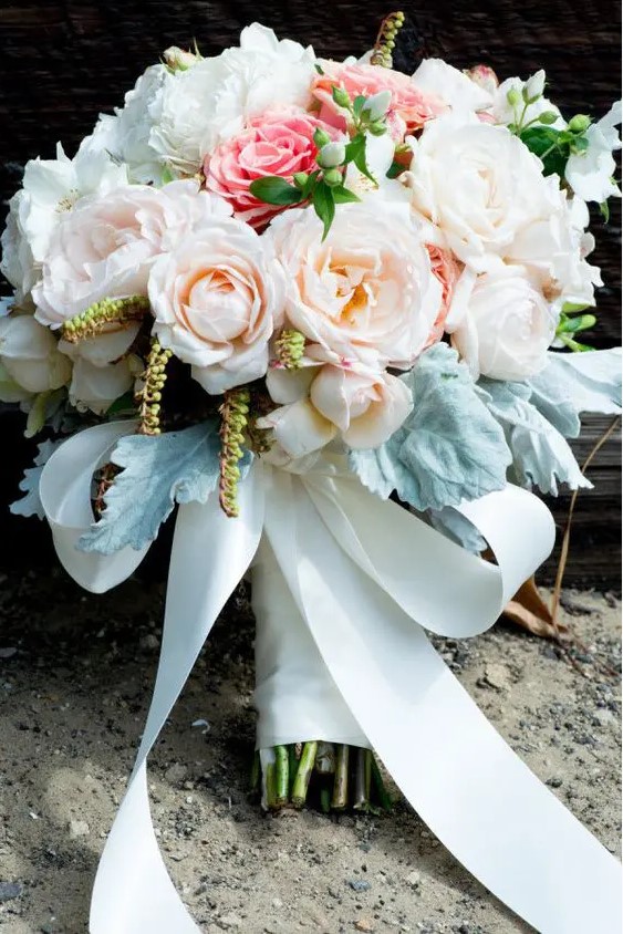 a classic wedding bouquet with blush, pink and white blooms, pale foliage and a white silk ribbon bow is amazing