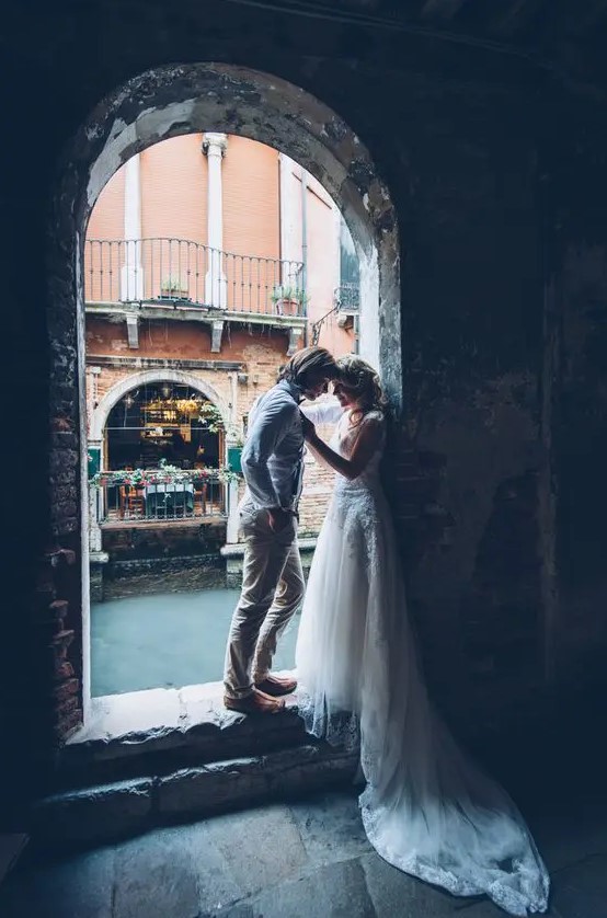 a couple in an arch in Venice looks really beautiful and the shot is very romantic