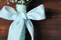 a delicate wedding bouquet of baby’s breath, aqua yarn and an aqua bow of silk ribbon for a bride or a bridesmaid
