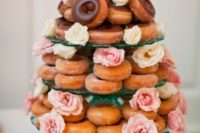 a donut tower with usual and glazed donuts and pink and neutral blooms for a bridal shower