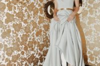 a dove grey A-line wedding dress with a deep neckline, a shiny belt and catchy shoes with socks