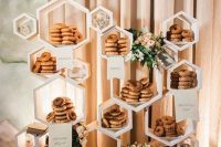 a fun hexagon wedding dessert stand with greenery and blooms can be used not only for donuts but for many other sweets, too