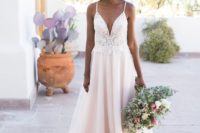 a girlish wedding ballgown with a white lace bodice on spaghetti straps and a plunging neckline, and a blush skirt