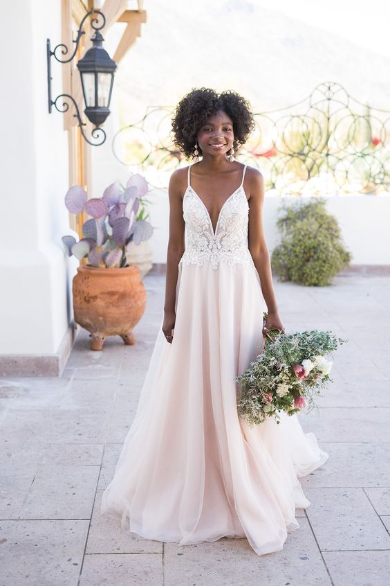a girlish wedding ballgown with a white lace bodice on spaghetti straps and a plunging neckline, and a blush skirt