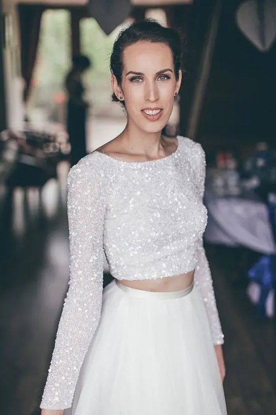 a glam bridal look with a white sequin crop top with long sleeves and an A-line skirt is a bold and stylish idea to show off your style