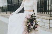 a gorgeous bridal look with a white lace crop top, a pink watercolor pleated skirt with a train, with a fern bridal crown and a matching bouquet