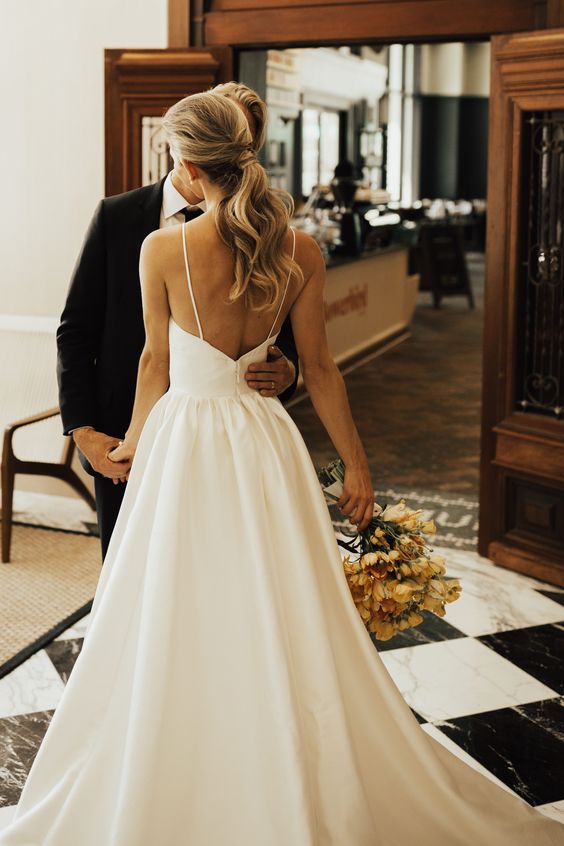 a gorgeous plain wedding ballgown with spaghetti straps, an open back and a sweeping train is very refined