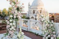 a jaw-dropping Venice wedding altar with blush and white blooms and greenery, with amazing views of the city