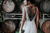 a lace applique mermaid wedding dress with an open back showing off the jaw-dropping colorful back tattoo