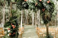 a lush tropical wedding arch decorated with monstera leaves and pink flowers is elegant