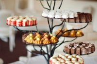 a metal tree-like wedding dessert stand is a very creative idea for a woodland or some relaxed rustic wedding