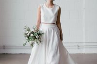 a minimalist two-piece wedding dress with a sleeveless crop top with a scoop neckline, a pleated plain high low skirt with a train