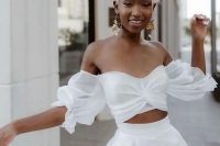 a modern white bridal separate with an off the shoulder top with puff sleeves and a high waisted pleated A-line skirt is fantastic