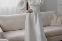 a modest and chic white silk midi wedding dress with puff sleeves, a high neckline, sheer embellished shoes