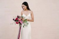 a neutral silk slip dress with a statement necklace and a train can be highlighted with a bright wedding bouquet