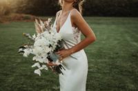 a plain mermaid wedding gown with a deep neckline and side lace inserts plus a sweeping train looks wow