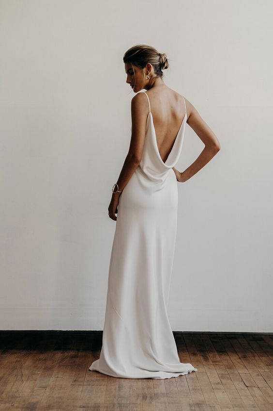 a plain slip wedding dress with a cowl open back and a small train for a minimalist bride