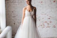 a refined A-line wedding dress with a draped bodice, a lace neckline, a layered tulle skirt for a chic bridal look