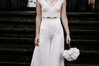 a refined modern bridal outfit with a plain crop top, high waisted flare silk pants, statement earrings and a pearl headpiece