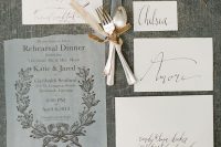 a semi sheer rehearsal dinner invitation with a raw edge and chic calligraphy and botanical prints for a refined event