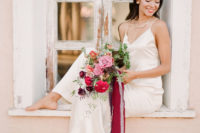 a simple spaghetti strap silk maxi dress with a small train and a statement necklace for an edgy modern bride