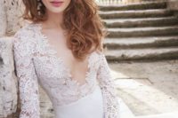 a stunning wedding dress with long sleeves and a lace bodice with a plunging neckline, a plain skirt