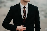 a stylish groom’s look with a black suit, a white shirt and a dark floral tie plus a brown hat is lovely for an Icelandic wedding