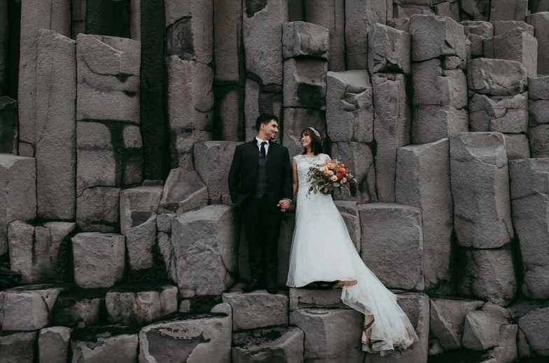 A stylish three piece wedding suit with a grey waistcoat, a lace embellished A line wedding dress with a train