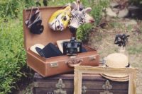 a vintage suitcase with various animal masks, vintage frames and vintage cameras for your wedding photo booth