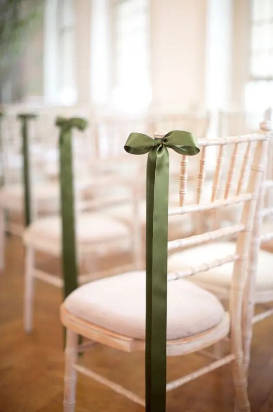 a white chair accented with a green silk bow and nothing else for a chic and tasteful wedding aisle look