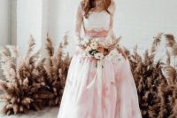 a white lace crop top with long sleeves paired with a pink marble full skirt with a train for a romantic and girlish look