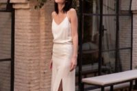 a white silk slip wedding dress with a side slit and vintage-inspired sparkling shoes for a casual bride